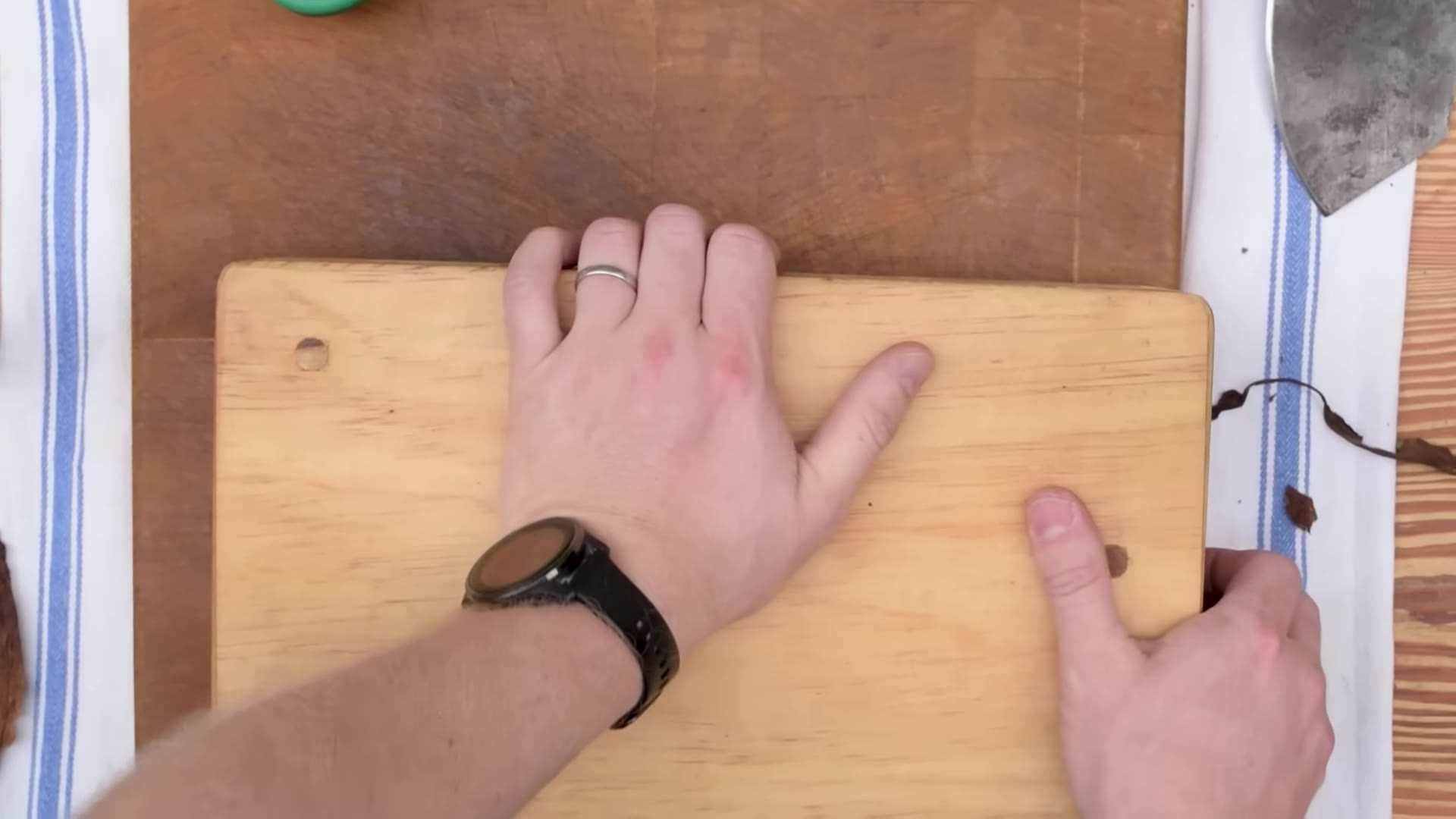 Hands pressing and shaping the tobacco bunch against a small wooden board